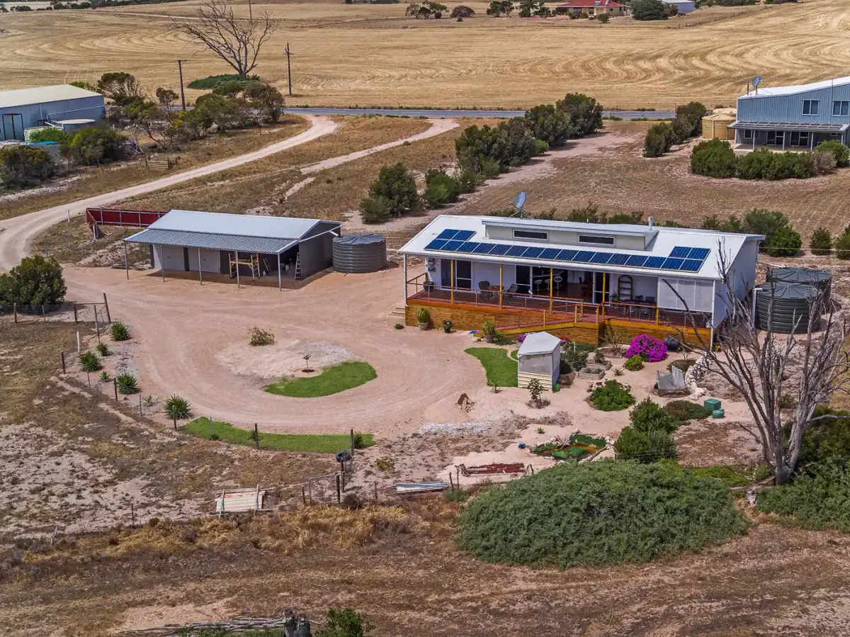 Aerial photograph of a rural homestead with sheds and a long gravel drive, booked and delivered through FotoPal