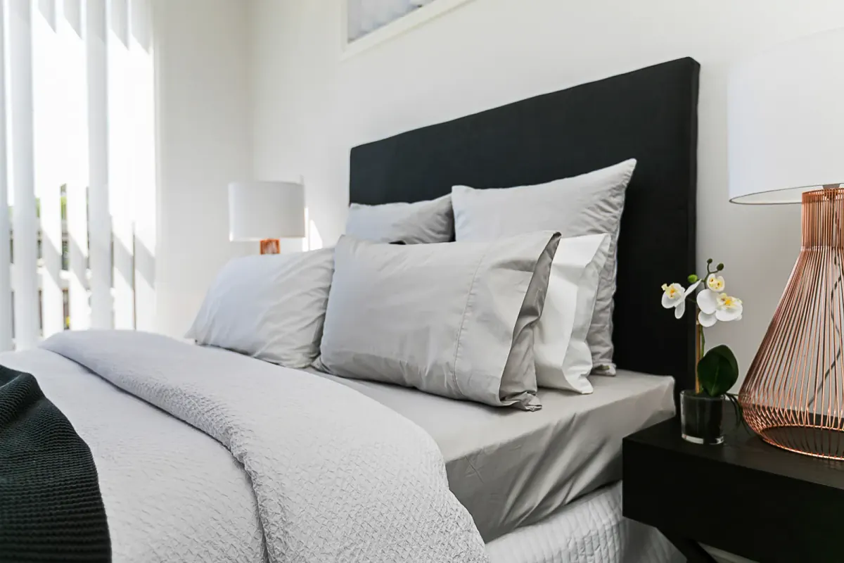 Bedroom with grey linen and a black headboard