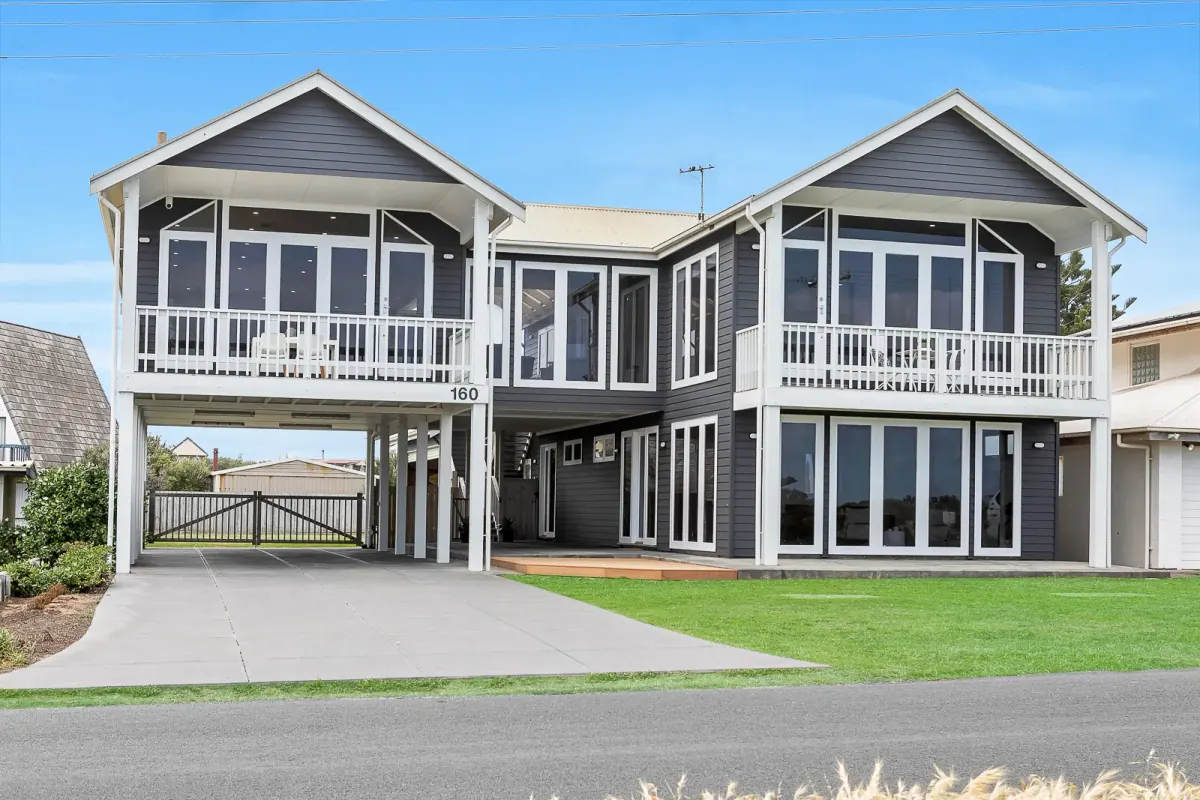 Two-storey coastal home with white balconies, delivered to the agent in a branded FotoPal gallery